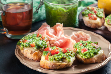 Bruschetta with fresh pesto, mozzarella and cherry tomatoes on a plate