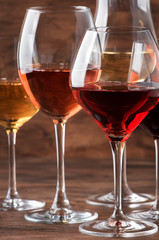 Wine set. Red, white and rose wine in assortment in wineglasses. Wine tasting, vintage wooden...