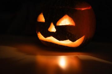 Alone head of the pumpkin inside the dark room. Only candle make a light during october halloween...