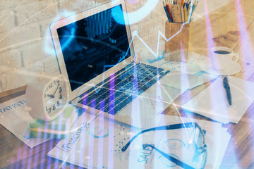 Financial chart drawing and table with computer on background. Multi exposure. Concept of international markets.