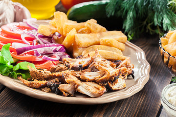 Greek gyros dish with french fries and vegetables