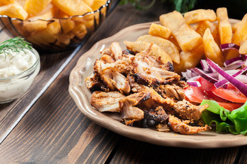Greek gyros dish with french fries and vegetables