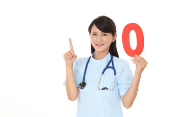 数字ゼロを持ち指さす看護師