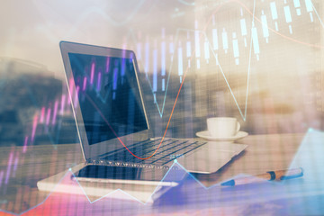 Stock market graph on background with desk and personal computer. Multi exposure. Concept of financial analysis.