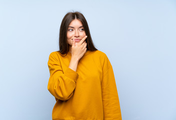 Caucasian young woman over isolated blue wall thinking an idea