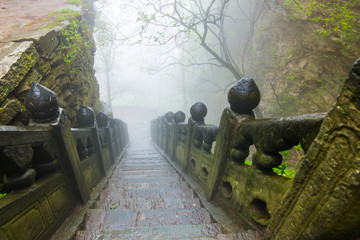 The steps of stair in ancient taoist way to secret place for martial arts during foggy morning