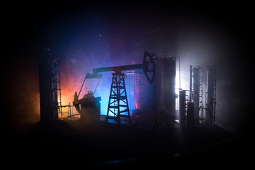 Artwork decoration. Oil pump and oil rig energy industrial machines for petroleum at night with fog and backlight. Oil refining factory. Energy industrial concept. Selective focus