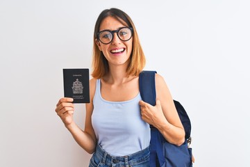 Beautiful redhead student woman wearing backpack and holding passport of canada with a happy face...