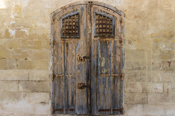 Fototapeta na wymiar Vintage old warehouse brown door with ancient limestone brick wall
