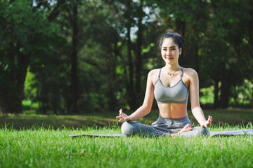 Fitness asian woman doing yoga in park