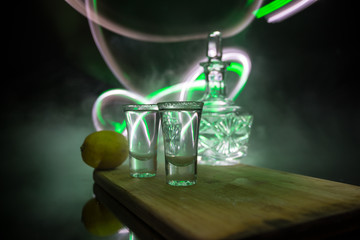 Club drink concept. Tasty alcohol drink cocktail tequila with lime and salt on vibrant dark background or glasses with tequila at a bar