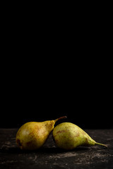  two pears in black background with copy space