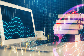Stock market chart hologram drawn on personal computer background. Multi exposure. Concept of investment.