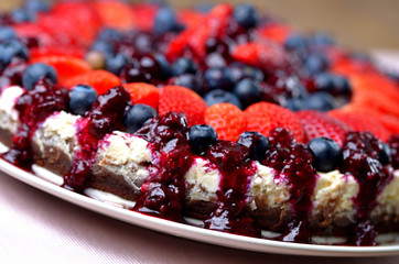 Detail of cake with fresh strawberries, blueberries and cherry jam.