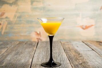 Autumn cocktail with pumpkin and orange juice in martini glass on the rustic background. Selective focus. Shallow depth of field.