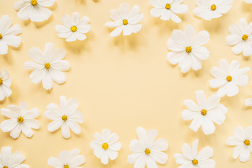 Minimal styled concept. Wreath made of white daisy chamomile flowers on pale yellow background. Creative lifestyle, summer, spring concept. Copy space, flat lay, top view.