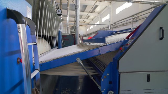 Video of industrial washed laundry ironing machine for big amount of textiles