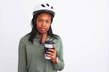 Young african american woman wearing bike helmet and drinking coffee over isolated background with a confident expression on smart face thinking serious