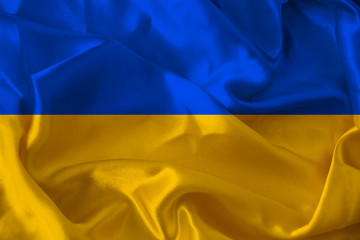 beautiful photo of the colored national flag of the modern state of Ukraine on textured fabric, concept of tourism, emigration, economics and politics, closeup