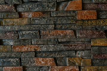 Fragment of the wall of the room, lined with dark natural stone. Close up
