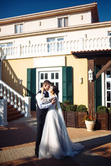 Newlyweds tenderly hug, kiss and enjoy each other. Walk of lovers. Amazing smiling wedding couple. Pretty bride and stylish groom. Romantic moment. Love. Together. Wedding. Marriage.