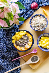Breakfast bowl with oat, yogurt, mango, persimmon and chia, top view