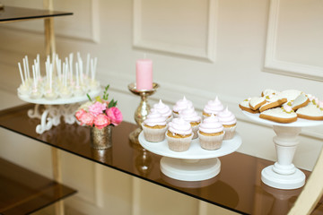 Event table with sweets, minimal decorated with fresh flowers