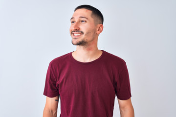 Fototapeta premium Young handsome man standing over isolated background looking away to side with smile on face, natural expression. Laughing confident.