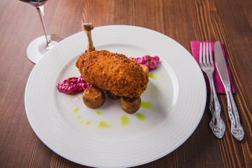 Chicken Kiev, Ukrainian cuisine. Chicken cutlet in bread crumbs stuffed with butter served with potato and beetroot salad on a brown table background