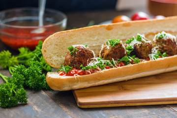baguette sandwich with vegan lentil  meatballs tomato sauce grated cheese parsley close up