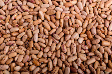 Natural background of many fresh organic red beans in warm light, top view or flat lay of healthy food