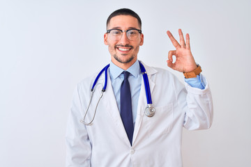 Fototapeta premium Young doctor man wearing stethoscope over isolated background smiling positive doing ok sign with hand and fingers. Successful expression.