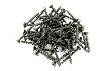 Black screws isolated on white. View from above. Pile of new black screws isolated on a white background. Steel screws on wood close-up. Fixing screws for construction on a white background.