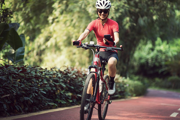 Fototapeta na wymiar Riding on bike path,using smartphone while riding bike on sunny day
