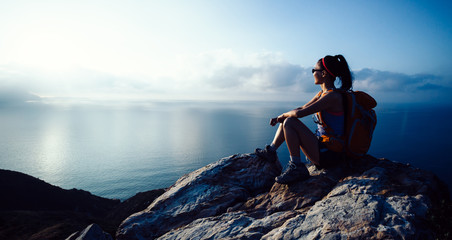 Young woman hiker enjoy the view at sunrise seaside mountain peak - Powered by Adobe
