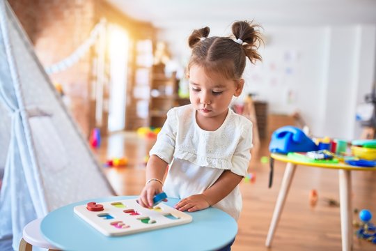 Young beautiful toddler learning mathematics playing with maths game at kindergaten