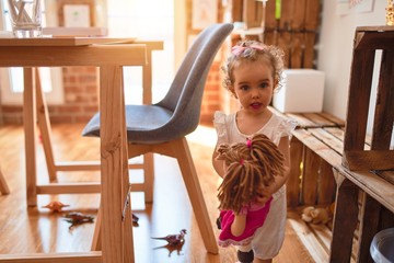 Beautiful caucasian infant playing with toys at colorful playroom. Happy and playful at kindergarten.