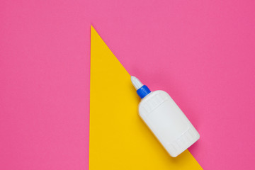 Bottle of glue on a color studio paper background. Top view