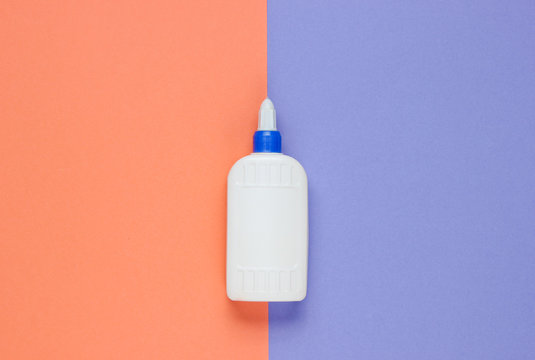 Bottle of glue on a color studio paper background. Top view