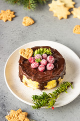 Delicious New York cheesecake with chocolate ganache, raspberries and cookies with fir branches. Festive decoration. 
