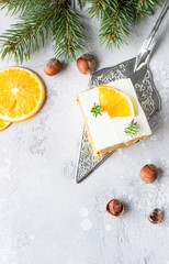 Carrot cake pieces with cream cheese frosting, decorated with dried orange fruit slices and anise. Festive decoration. 
