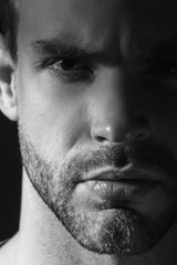 Obraz premium Black and White Muscle strong beautiful stripped male model in casual cloath on black isolated font background