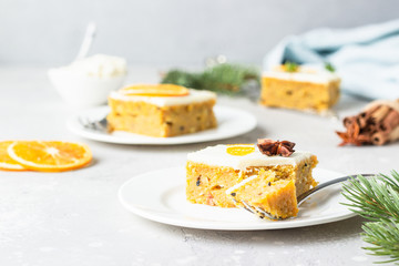 Carrot cake pieces with cream cheese frosting, decorated with dried orange fruit slices and anise. Festive decoration. 