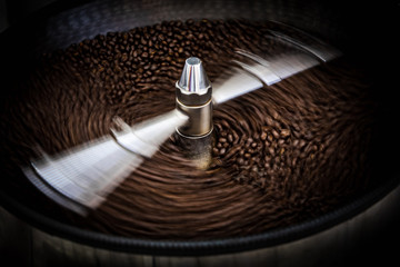 fresh coffee beans and roasted spinning cover professional machine close up photo and black background long exposure shot and movement coffee beans detail at factory chiang rai Thailand - obrazy, fototapety, plakaty