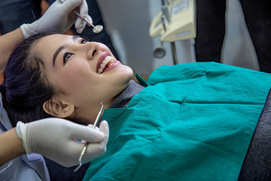 Dentist examining mouth teeth of beautiful young Asian woman in hospital clinic dental health care beautify oral hygiene concept