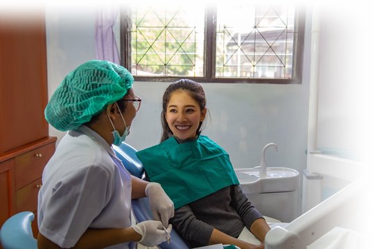 Dentist examining mouth teeth of beautiful young Asian woman in hospital clinic dental health care beautify oral hygiene concept
