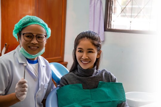 Dentist examining mouth teeth of beautiful young Asian woman in hospital clinic dental health care beautify oral hygiene concept