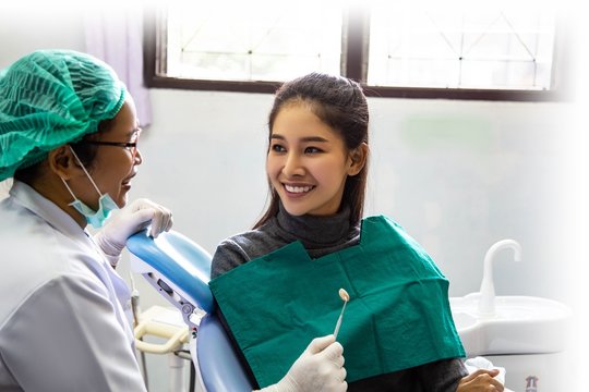 Dentist examining mouth teeth of beautiful young Asian woman in hospital clinic dental health care beautify oral hygiene concept