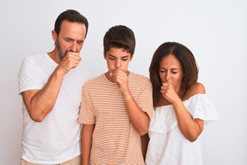 Family of three, mother, father and son standing over white isolated background feeling unwell and...
