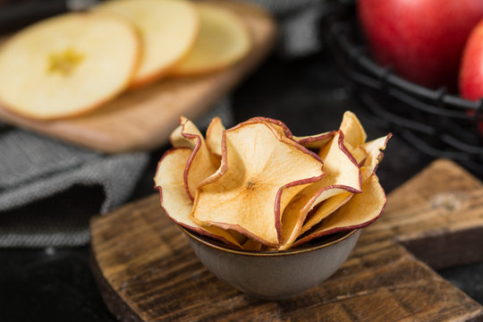 Apple chips in a gray bowl on a black table. Place for text